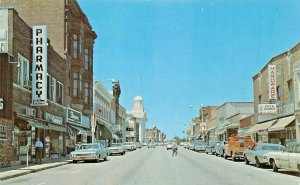 DODGEVILLE WISCONSIN~MAIN STREET-PHARMACY-HARDWARE-BANK SIGNS-CARS-1960 POSTCARD