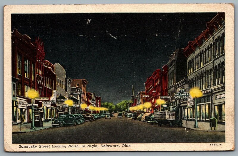 Postcard Delaware OH c1946 Sandusky Street Looking North at Night Old Cars Shops