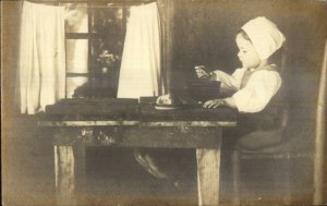 Little Girl at Table Eating From Bowl c1910 Real Photo Postcard AZO