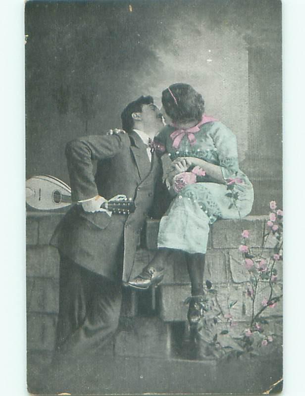 Pre-Linen foreign MAN WITH GUITAR KISSING WOMAN ON BRICKWALL J4352