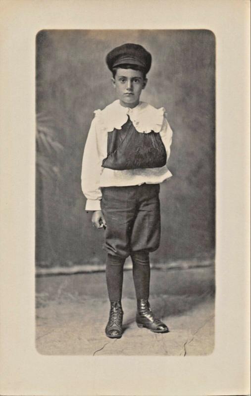 YOUNG BOY WITH-BROKEN ARM? IN SLING-PERIOD CLOTHING REAL PHOTO POSTCARD