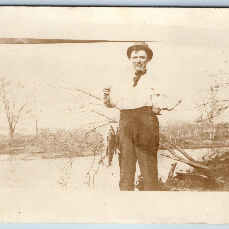 c1910s Cool Man Fish Catch RPPC Fisherman Smokes Pipe Outdoors Nature Photo A174
