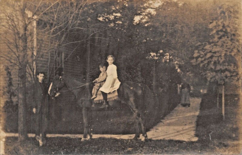 CHILDREN SITTING ON HORSE-REAL PHOTO POSTCARD 1910s