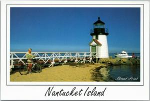 Brant Point lighthouse with boat and female bicyclist, Nantucket Massachusetts