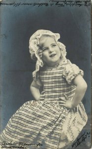 c1908 RPPC Pretty Little Blonde Girl in Lace Bonnet, Plaid Apron, Posted Denmark