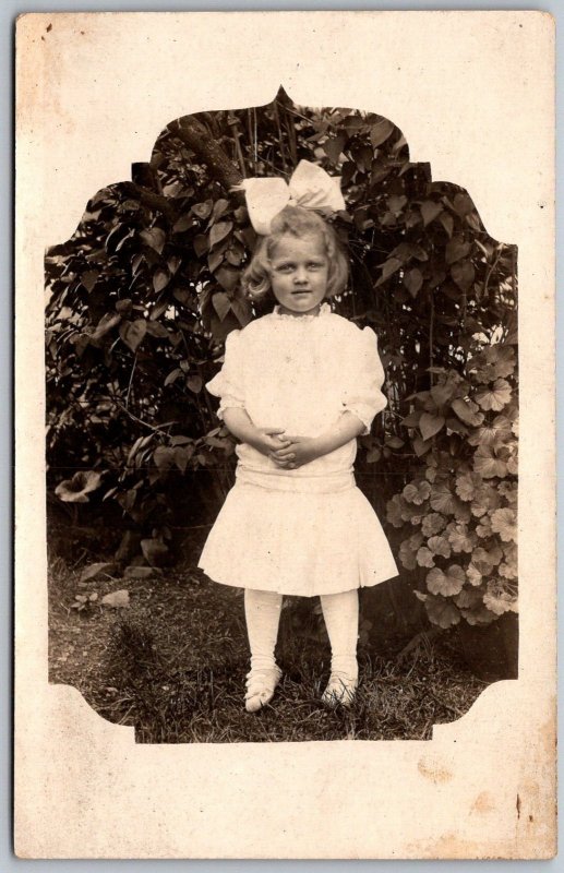 c1908 RPPC Real Photo Postcard Girl Large Bow Standing Outside Foliage