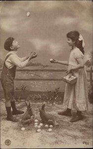 Easter Children Boy & Girl Toss Eggs c1900s-10s RPPC Real Photo Postcard