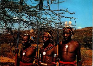 VINTAGE CONTINENTAL SIZE POSTCARD SUK TRIBAL WARRIORS IN KENYA AFRICA + STAMPS