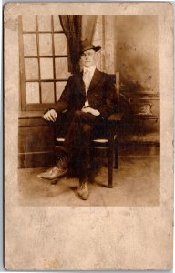 RPPC Confident Whipersnapper in suit and hat sitting next to window