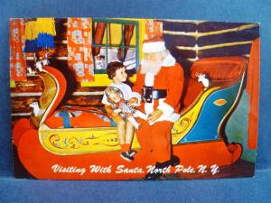 Postcard NY North Pole Visiting With Santa Little Girl w/ Doll on Sleigh