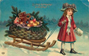 B582 Christmas greetings postcard girl pulling sledge apples & gingerbread 1923