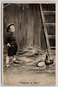 c1920 Young Boy Looking at Roaster & Egg in Barn You're a Liar Postcard