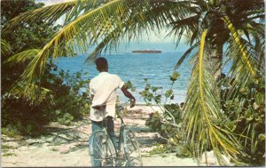 Postcard Cayman Islands Gunbay Boy with bicycle looking out to shipwreck on reef