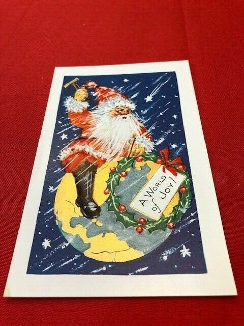 embossed postcard SANTA sitting on earth with hammer to nail a wreath on world