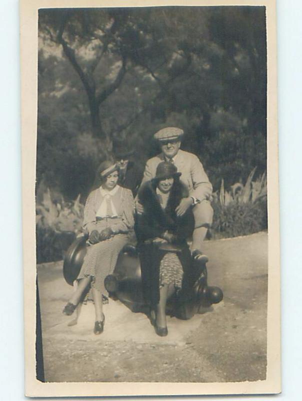 old rppc PEOPLE SITTING ON MILITARY CANNON country of Gibraltar HM1378