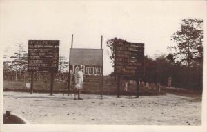 Cambodge - Carte photo d'un homme en tenue coloniale devant une publicité JO...