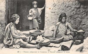 br104346 woman preparing couscous and woman painting the wool africa  real photo