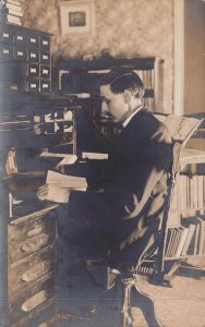 MAN READING AT MULTI SLOTTED DESK-FILE CABINET ON TOP~1910s REAL PHOTO POSTCARD