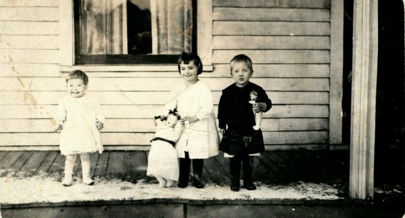 C. 1905 RPPC Cute Kids Holding Large Doll Dolls on Snowy Porch AZO Real Photo F1 