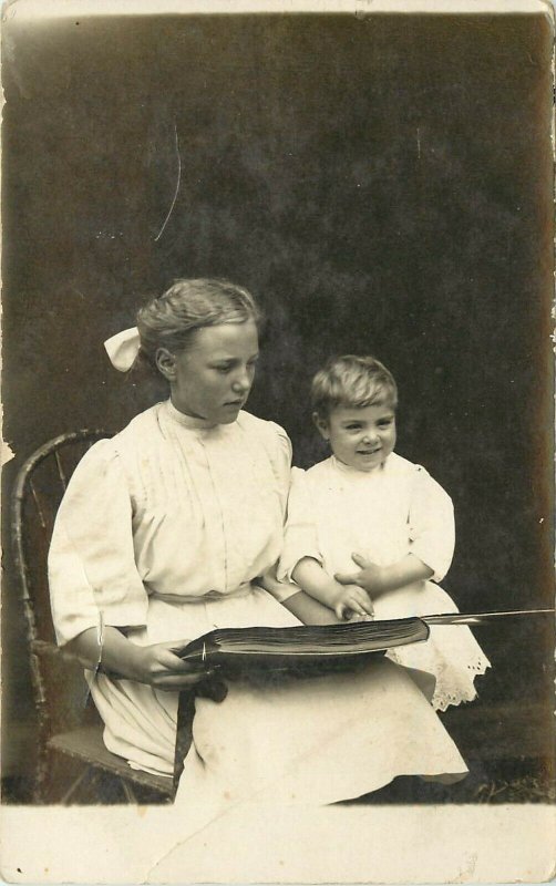 c1910 RPPC Beautiful Blonde Children Looking at Postcard or Photo Album Unposted 