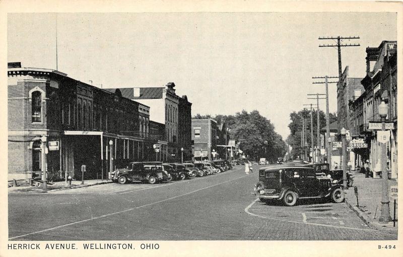 F64/ Wellington Ohio Postcard c1940s Herrick Avenue Stores Autos