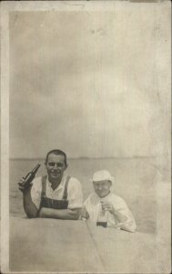 Men Drink From Bottle Partially Visible Label c1910 Real Photo Postcard