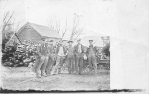 RPPC HOUSES LOGGING GROUP OF MEN MACHINERY REAL PHOTO POSTCARD (c. 1920s)