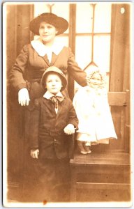 Woman with Two Children Formally Dressed at Church - Vintage Postcard