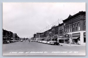 K1/ Storm Lake Iowa RPPC Postcard c1950s Lake Avenue Stores Autos  433