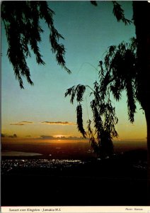 VINTAGE CONTINENTAL SIZE POSTCARD SUNSET OVER KINGSTON JAMAICA FLOWER STAMPS