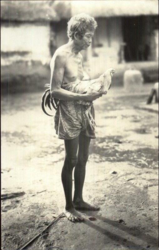 Indonesia? Older Semi-Nude Woman Holding Chicken in Street Real Photo Postcard 