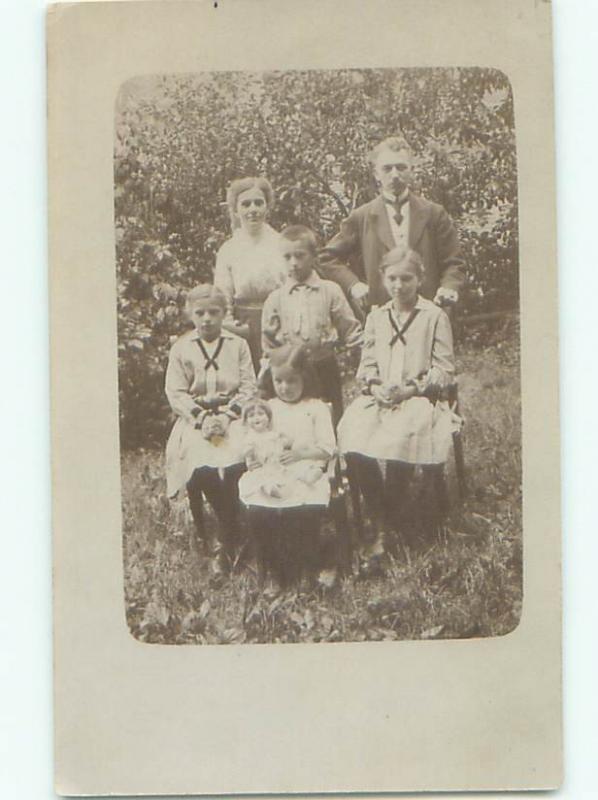 rppc 1920's GIRL HOLDING HER DOLL ON LAP AT FRONT OF GROUP AC8453