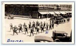 Downtown Postcard RPPC Photo Marching Band Cars Drugs Soda 1928 Vintage Posted