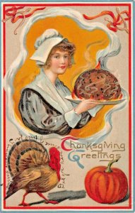 THANKSGIVING GREETINGS~YOUNG COLONIAL WOMAN CARRYING FOOD~EMBOSSED 1909 POSTCARD