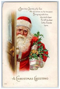 1915 Christmas Greetings Santa Claus At Door With Gift Presents Holly Postcard