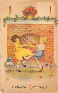 Yuletide greetings Children dancing in front of a fireplace D.P.O. , Disconti...