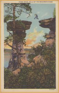 Wisconsin Dells, Wis., Man jumping onto Stand Rock - 
