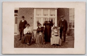 RPPC Victorian Women in Yard Sewing Reading Book Big Woman Two Men Postcard H30