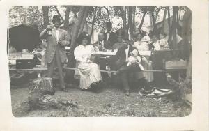 c1910 RPPC People in Fancy Dress & Hats at Picnic. Man holds a bottle of Wine