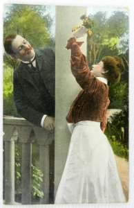 Gentleman Surprises Woman with Pink Flowers From Garden - Vintage Postcard