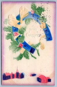 1910 MERRY CHRISTMAS BLUE HORSESHOE over TOWN HOLLY AIRBRUSHED EMBOSSED POSTCARD