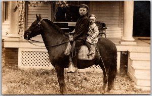 Two Young Boys on Black Horse Riding Front of Home RPPC Real Photo Postcard