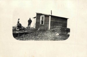 RPPC Postcard 2 Men with a Grindstone in fron of a Tiny Shack Chinook MT Blaine