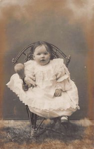 YOUNG BABY-ORNATE DRESS-HOLDS RATTLE~BORDON HAMPSHIRE ENGLAND PHOTO POSTCARD