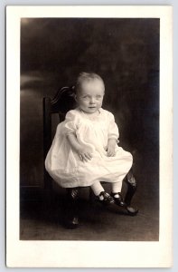 RPPC 1 Yr Old? Baby~Eyes Wide Open~Sheer White Gown~Mary Jane Shoes~Studio Chair