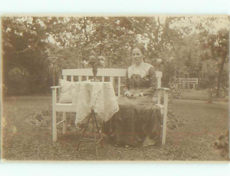 rppc 1920's WOMAN ON BENCH BESIDE FLOWER VASE ON STAND AC8878