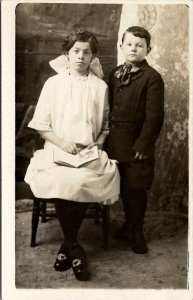 RPPC Girl Book Unique Braided Buckled Shoes and Young Boy Postcard U9