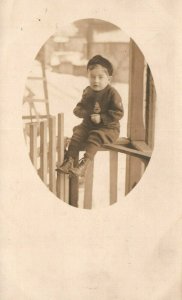 Vintage Postcard 1910's RPPC Young Boy Sitting on Porch Fence Portrait Photo