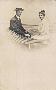 YOUNG COUPLE POSE N BOAT~INVERTED SPELLING OF ROCKAWAY~1900s REAL PHOTO POSTCARD