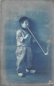 US37 postcard greetings card Germany boy with wooden shoes and hat smoking pipe